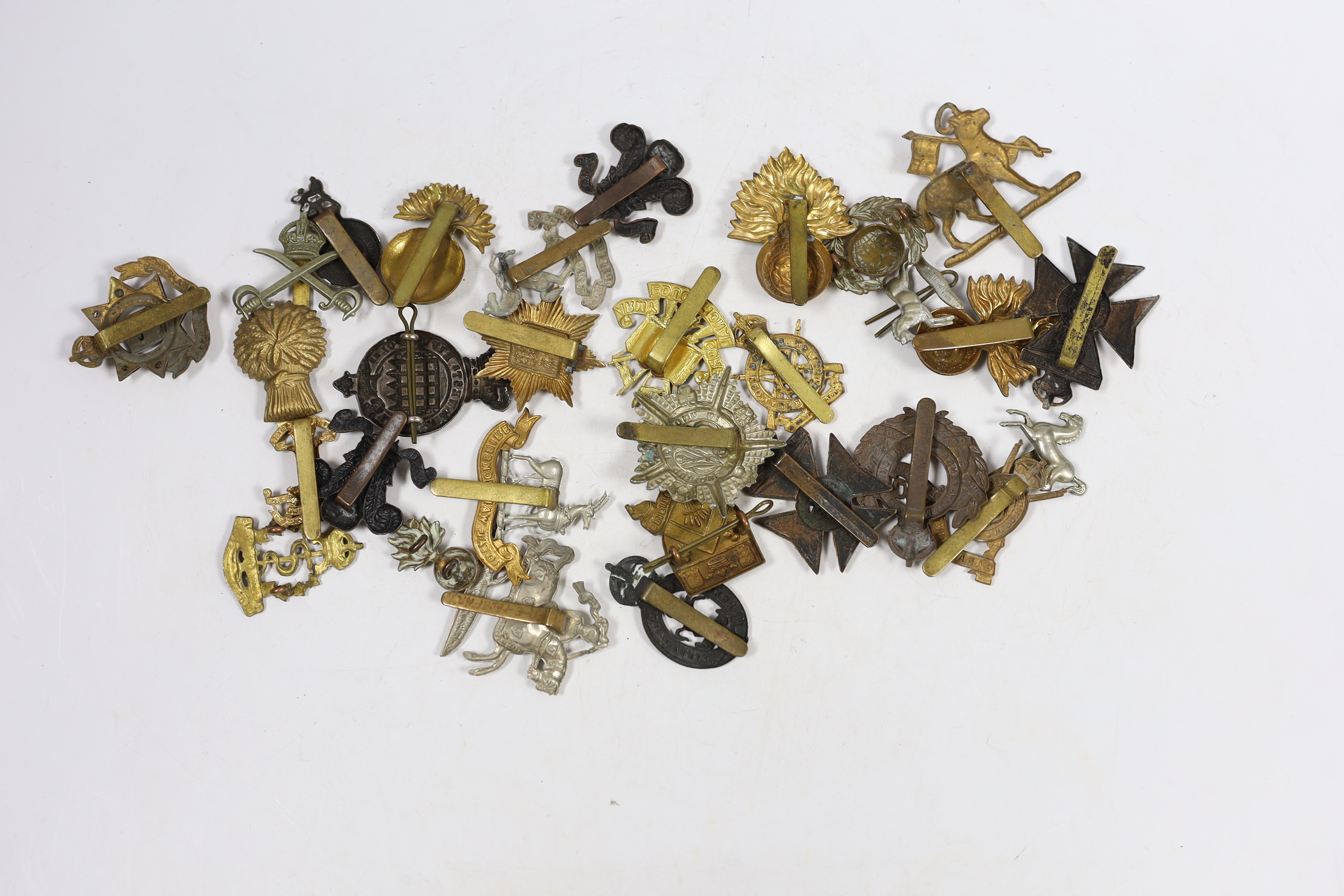 Thirty military cap badges including Royal Warwickshire, Hampshire Yeomanry Carabiniers, Inniskillin, Royal Canadian, AMC, Dorset, Army Educational Corps, London and West Rifle Volunteers, etc.